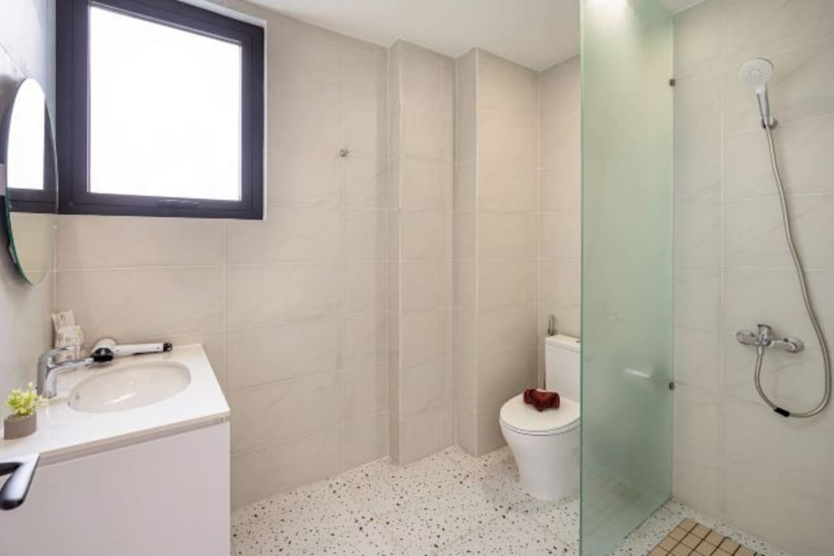A bathroom with a white sink, a toilet, and a glass-enclosed shower area.