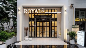 Entrada de un hotel con un cartel que dice 'ROYAL Hotel & Apartment'.