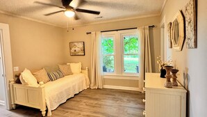 A bedroom with a bed, a dresser, a ceiling fan, and a window with curtains. -  NO CLEANING FEE Century farmhouse on Lake Keowee near Clemson (Seneca)