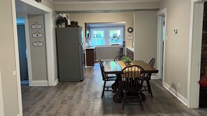 A spacious kitchen with a dining area, wooden flooring, and a view to the backyard. -  NO CLEANING FEE Century farmhouse on Lake Keowee near Clemson (Seneca)