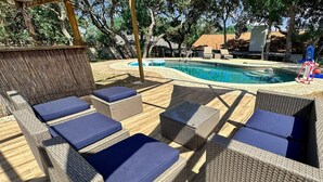 Un espace aménagé au bord de la piscine, avec des meubles en osier et un panier de basket.