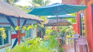 A tropical resort with a pool, outdoor seating, and lush greenery. - Pirate Galeon (Carcar)