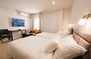 A hotel room with a bed, a desk, a chair, a TV, and a lamp. - Eng Fah Luang Hotel (Chiang Rai)