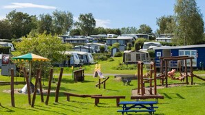 A campsite with mobile homes, a playground, and picnic tables. - 6 Person Holiday Park Home in Vipperod (Vipperod)