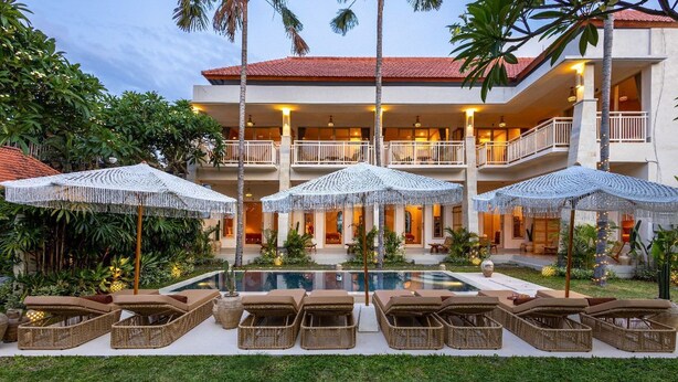 Un hôtel doté d’une piscine, de chaises longues et de parasols.