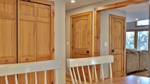 A room with wooden doors, a white bench, and a wooden table. - Lakeside Lodge at Fern Lake: 3BR/1BA Waterfront w/ Dock (Leicester)