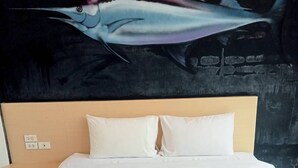 Habitación de hotel con una cama, dos almohadas y dos toallas dispuestas sobre la cama.