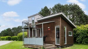 Une maison moderne à deux étages, dotée d’un balcon, d’un garage et d’une pelouse bien entretenue.