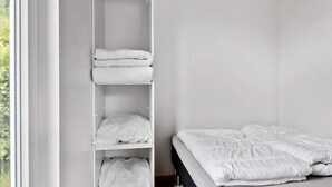 Una camera da letto con un letto, un armadio contenitore e una finestra.