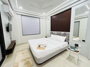 A modern bedroom with a bed, bedside table, and a large mirror.