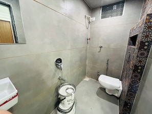 A small, compact bathroom with a toilet, bidet, and sink.