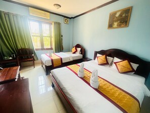 A hotel room with two beds, a desk, a chair, and a window with curtains. - Khampaseuth Hotel (Vang Vieng)