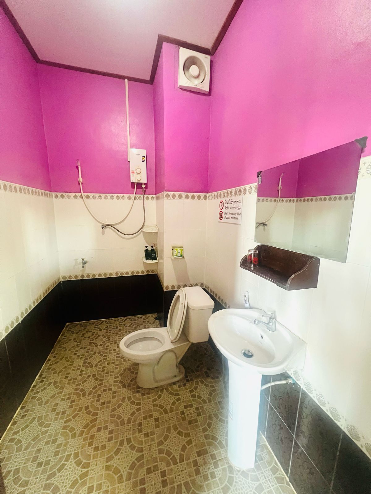 A bathroom with a toilet, sink, and a shower area.