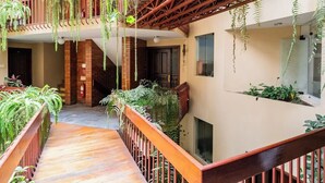 A multi-level atrium with wooden flooring, metal railings, and hanging plants. - LOFT  1-bedroom apartment in San Borja with WiFi (San Borja)