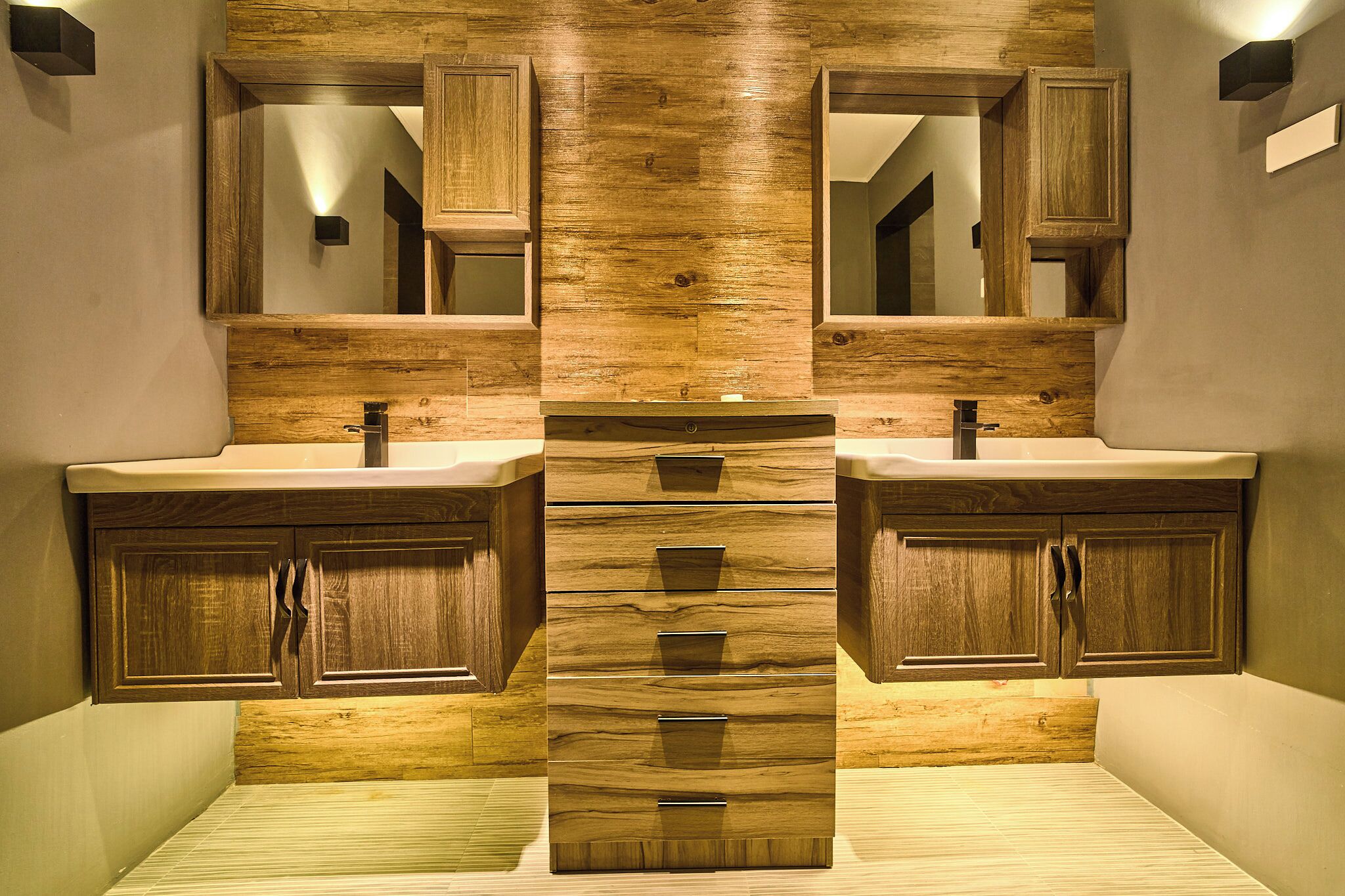 A bathroom with wooden cabinetry and two sinks.