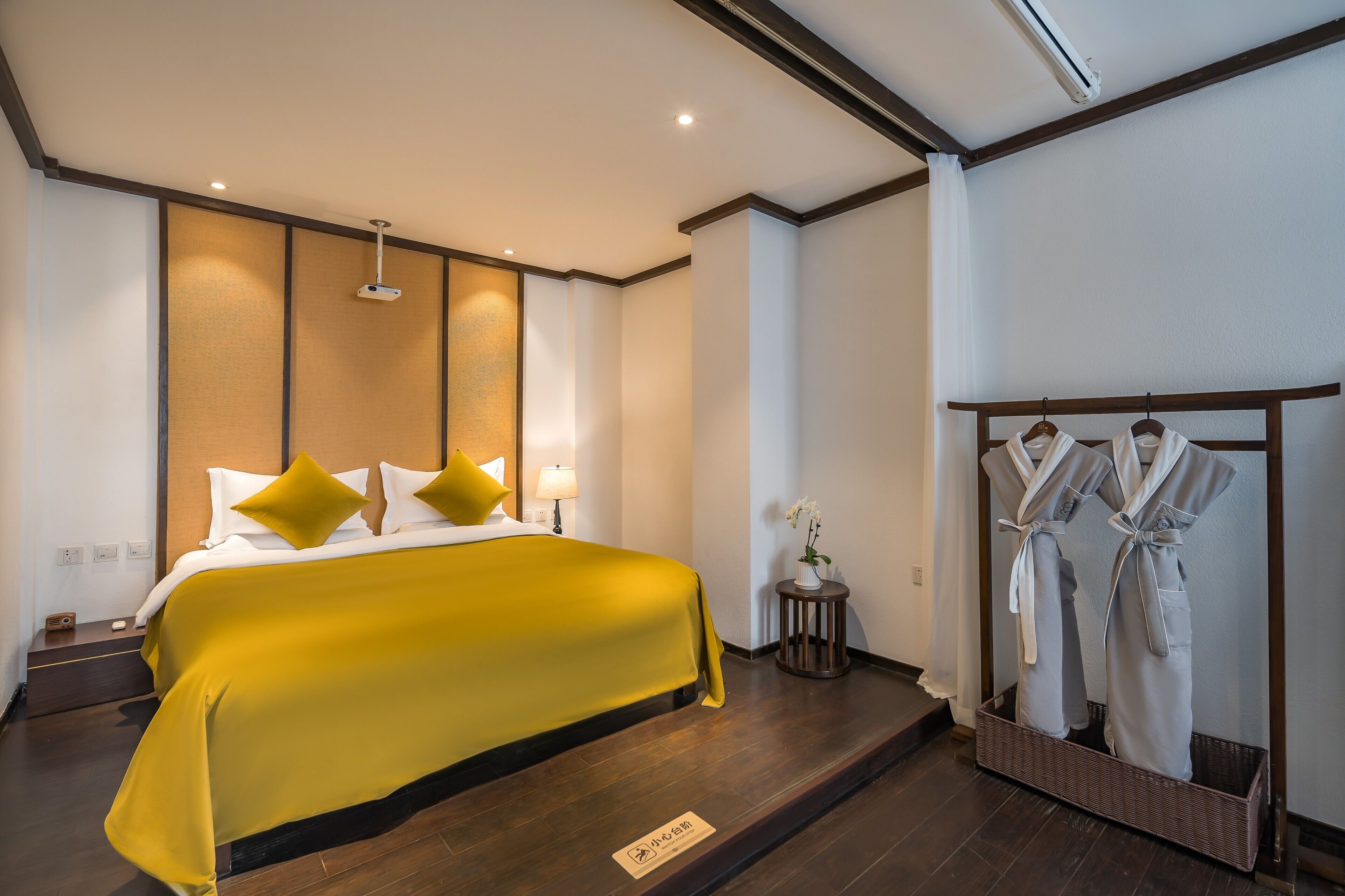 Habitación de hotel con cama, espejo y perchero.