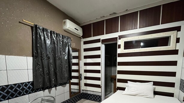 Una habitación de hotel con cama, una silla, una mesa y una ventana.