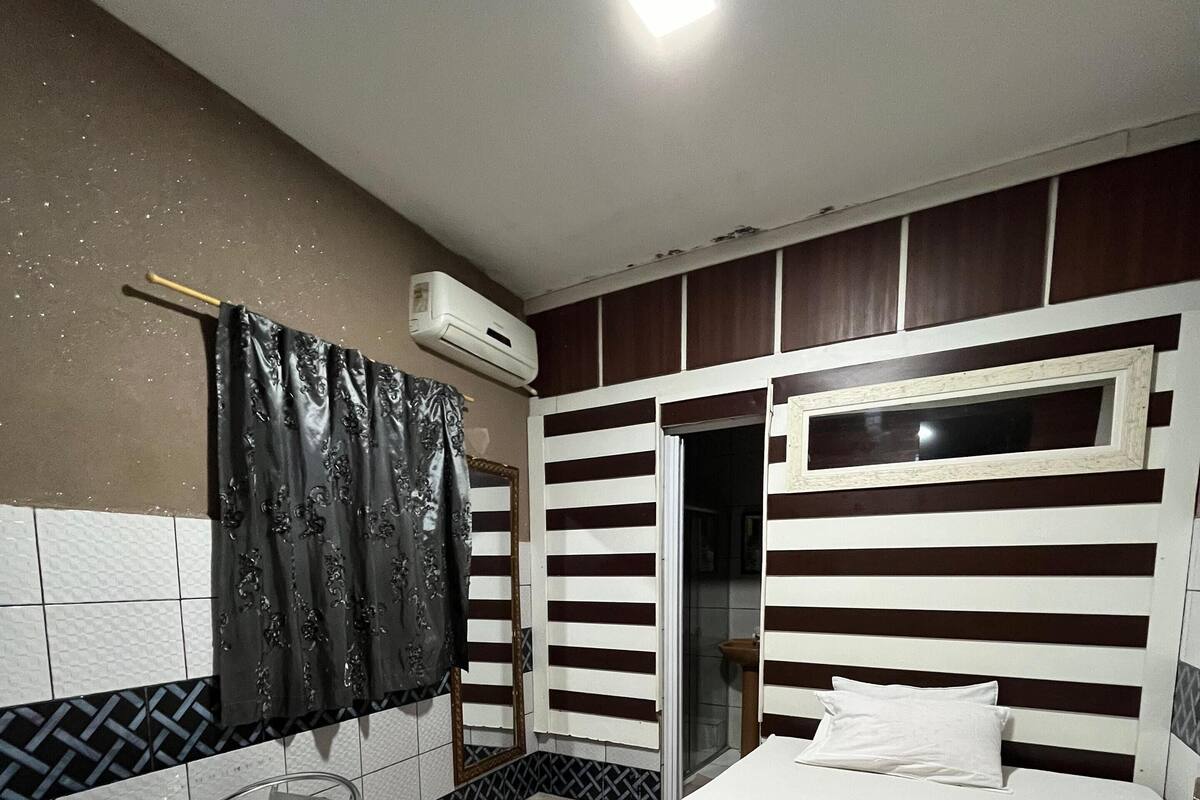 Une chambre d’hôtel avec un lit, une chaise, une table et une fenêtre.