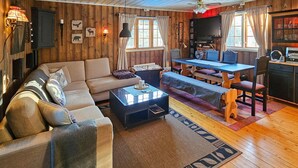 Un salón acogedor con sofá, mesa de centro y comedor con mesa y sillas.