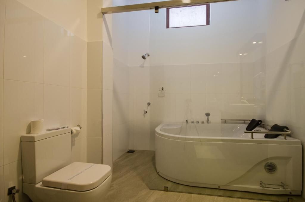Un baño moderno con inodoro, bañera y cabina de ducha.