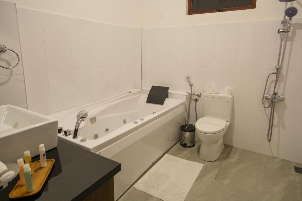 Une salle de bain moderne équipée d’une baignoire, de toilettes et d’une douche.