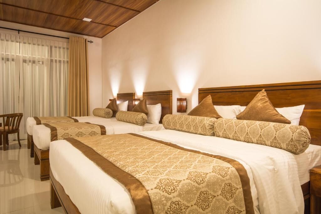 Une chambre d’hôtel avec deux lits, chacun doté d’une tête de lit en bois et d’une literie de couleur beige.