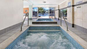 An indoor swimming pool with multiple lanes and a water slide. - Pacific Regis (Burleigh Heads)