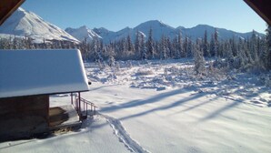 A snowy mountain landscape with a cabin and a clear sky. - Igloo City Cabin Rentals #1 Charming Cabin in Broad Pass at the Igloo Property (Cantwell)