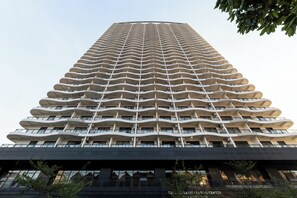A tall, modern building with a unique wavy facade and multiple balconies. - TK Star Condo by Soben Homes (Phnom Penh)