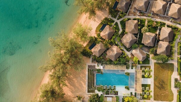 An aerial view of a resort with overwater bungalows, a central swimming pool, and a beach. - JATI Koh Russey (Prey Nob)