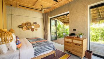 A bedroom with a bed, bedside table, and a view of greenery outside.