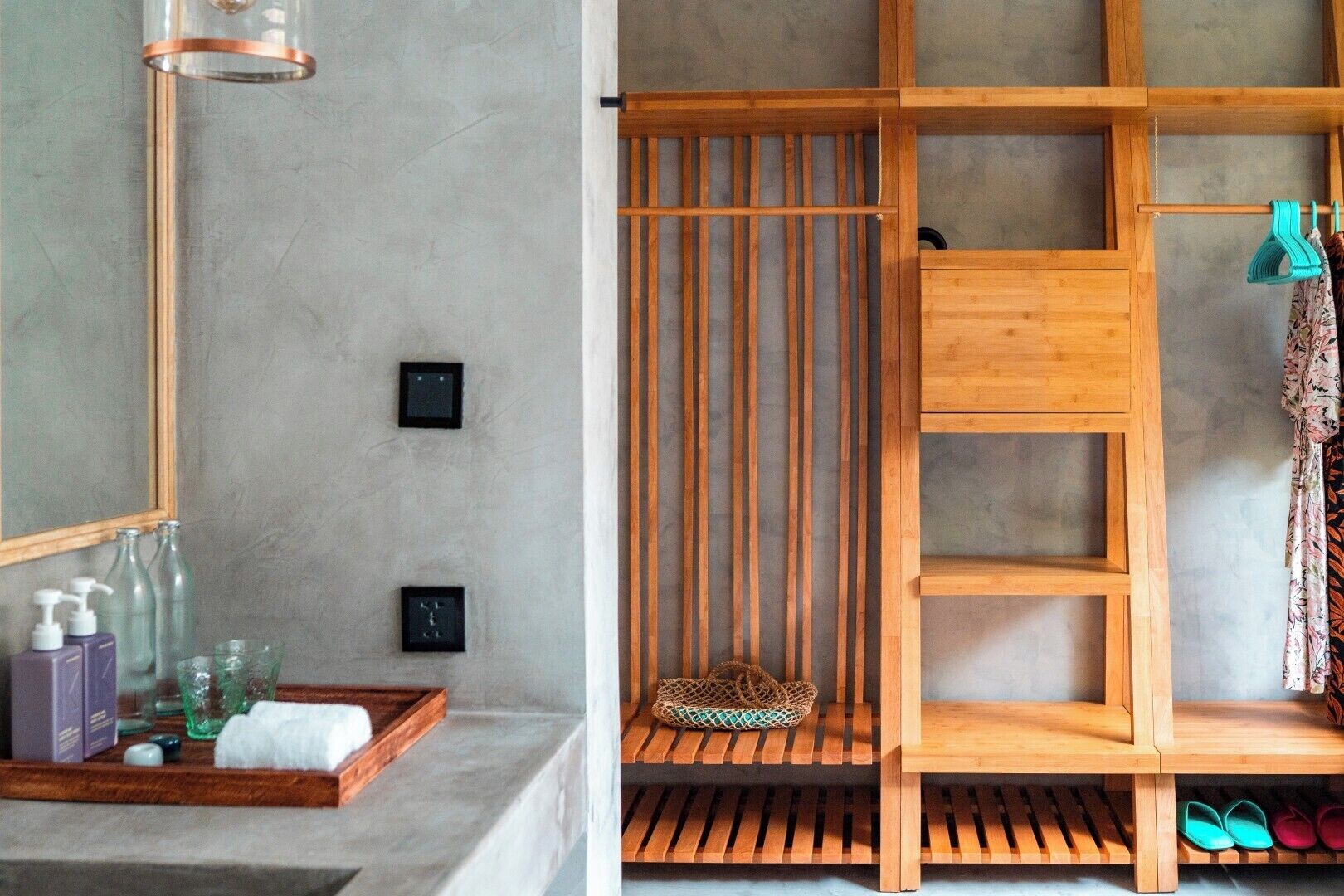A bathroom with a wooden vanity, a towel rack, and a shelf with shoes.