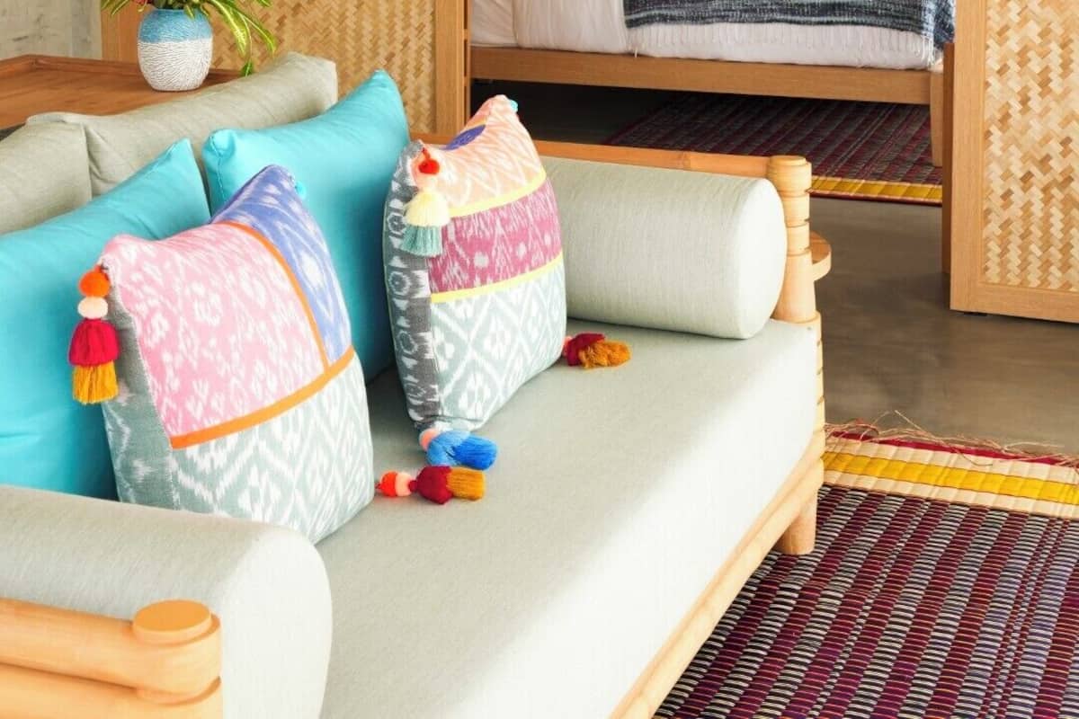 Quarto aconchegante com cama, um sofá e um lustre.