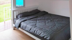 Une chambre à coucher avec un lit, une fenêtre et une vue sur l’extérieur.