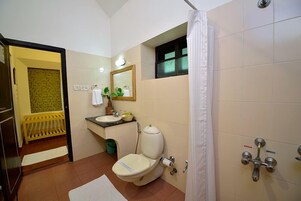 Casa de banho com sanita, lavatório e chuveiro.
