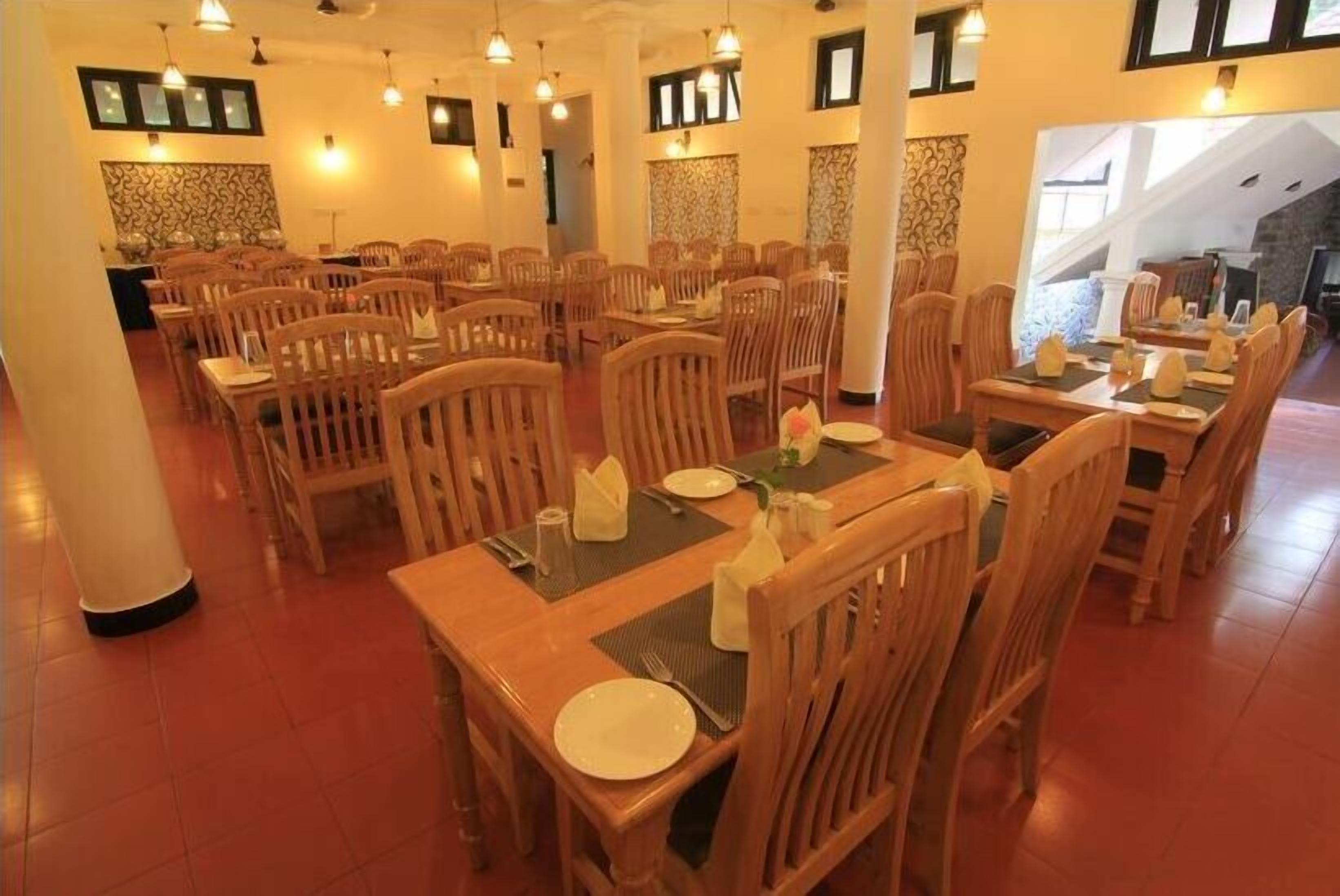 Ein Restaurant mit mehreren Holztischen und -stühlen, ansprechend angeordnet in einem großzügigen Raum.