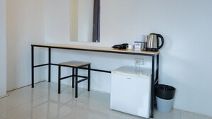 A compact kitchenette with a small refrigerator, a coffee maker, and a trash bin. - GO INN Night Bazaar Chiang Mai (Chiang Mai)