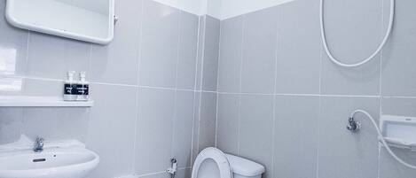 A small, modern bathroom with a toilet, sink, and shower.