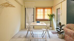 Un espacio habitable compacto con una mesa de comedor, sillas, un sofá y plantas en macetas.