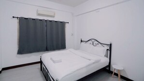 A single bed with a metal frame, white bedding, and a small bedside table. - GO INN Maya Chiang Mai (Chiang Mai)