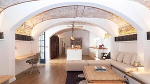 Un salón amplio con una mesa de centro de madera, un sofá y un comedor, con una cocina al fondo.
