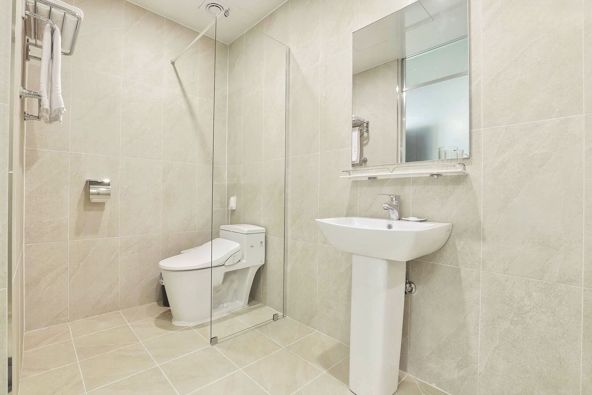 A modern bathroom with a toilet, sink, and shower.