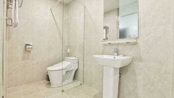 A modern bathroom with a toilet, sink, and shower.