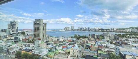 Un paisaje urbano costero con una mezcla de edificios residenciales y comerciales, un frente marítimo destacado y vistas al mar.