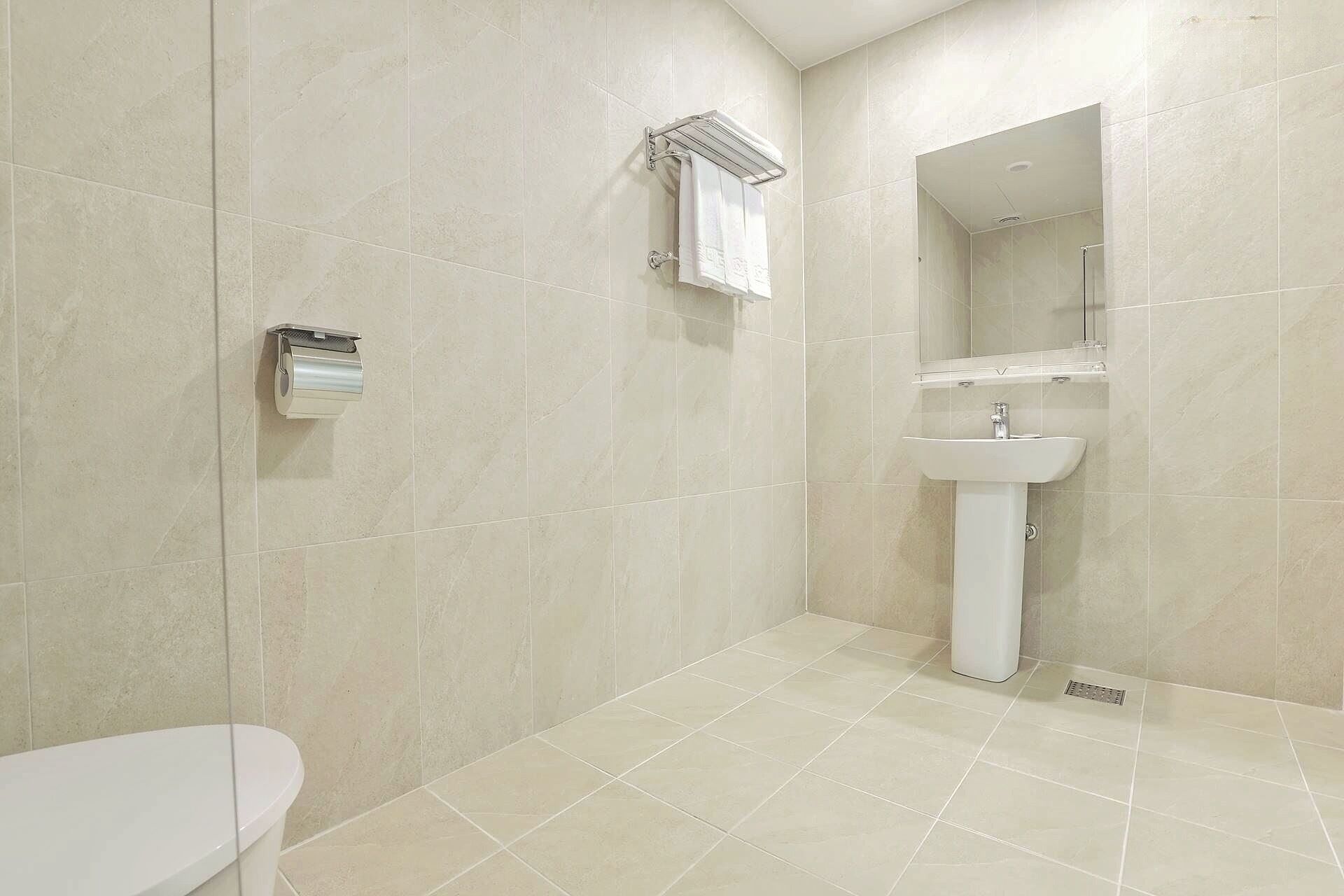 Un baño con inodoro, lavabo y zona de ducha.