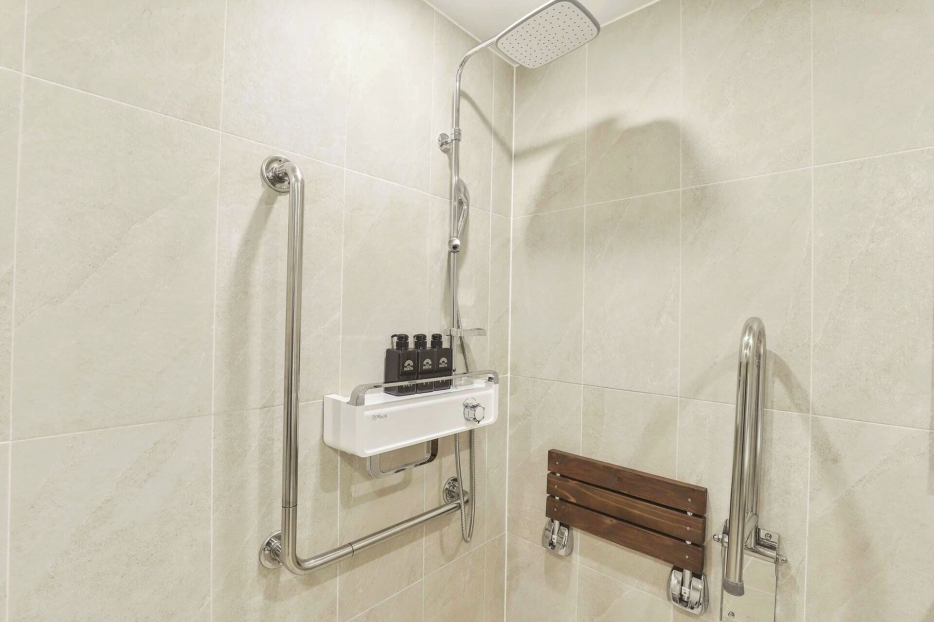 A shower area with a handheld showerhead, a handheld shower attachment, and a handheld shower control unit.