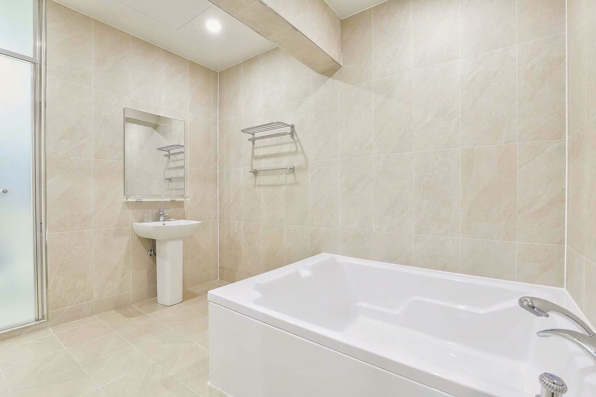 A modern bathroom with a bathtub, a sink, and a mirror.