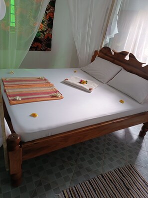 Restful retreat with a neatly made bed, featuring a comfortable mattress and pillows, and a cozy throw blanket.