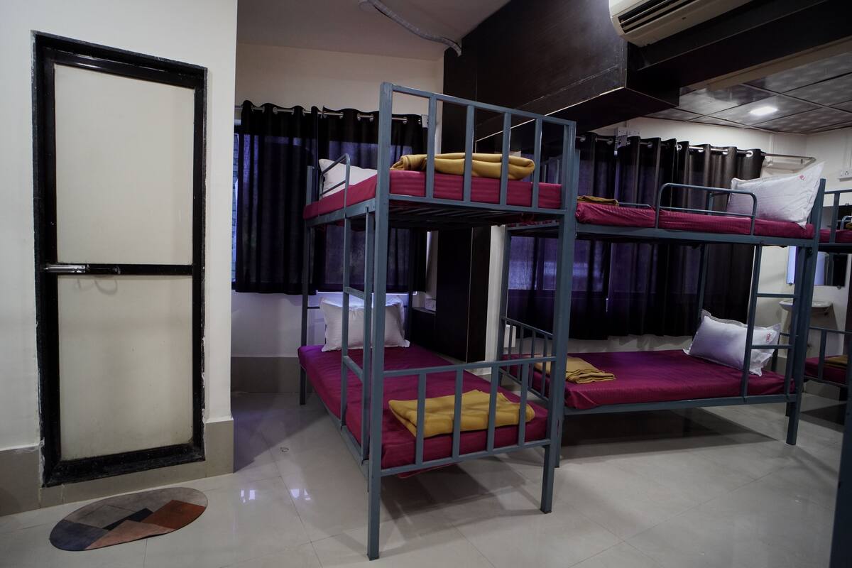 A bunk bed room with a door, curtains, and a tiled floor.