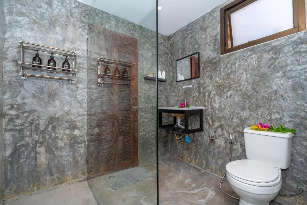 Ein Badezimmer mit Dusche, Toilette und Waschbecken.